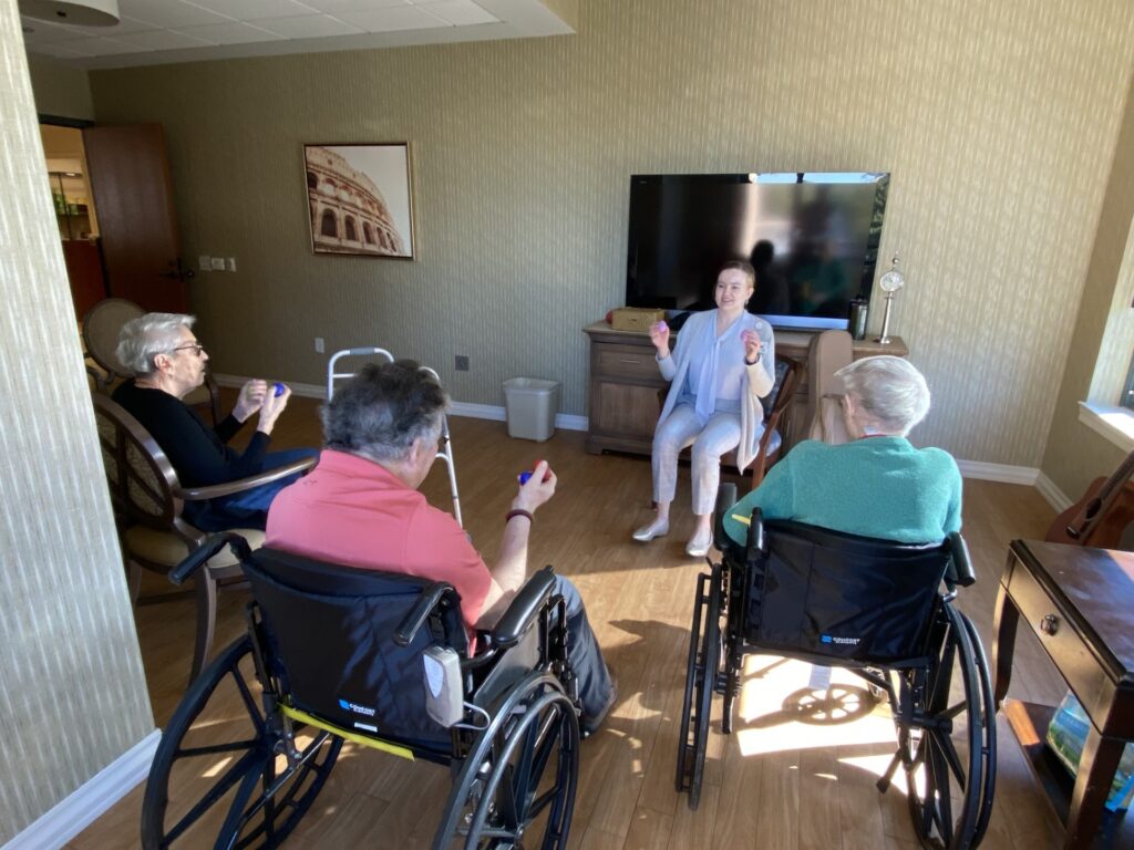Music Therapist Abigail Hanlon leading music therapy with GHA residents in the healthcare center.