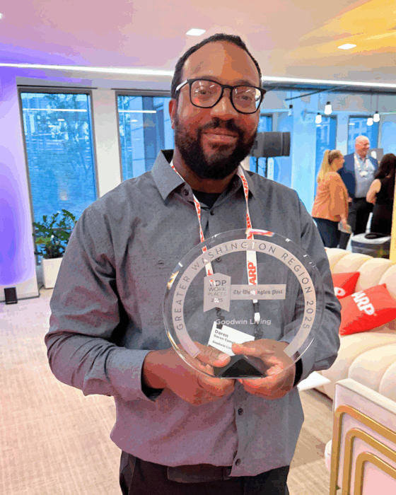 Leader Daren Campbell holding award